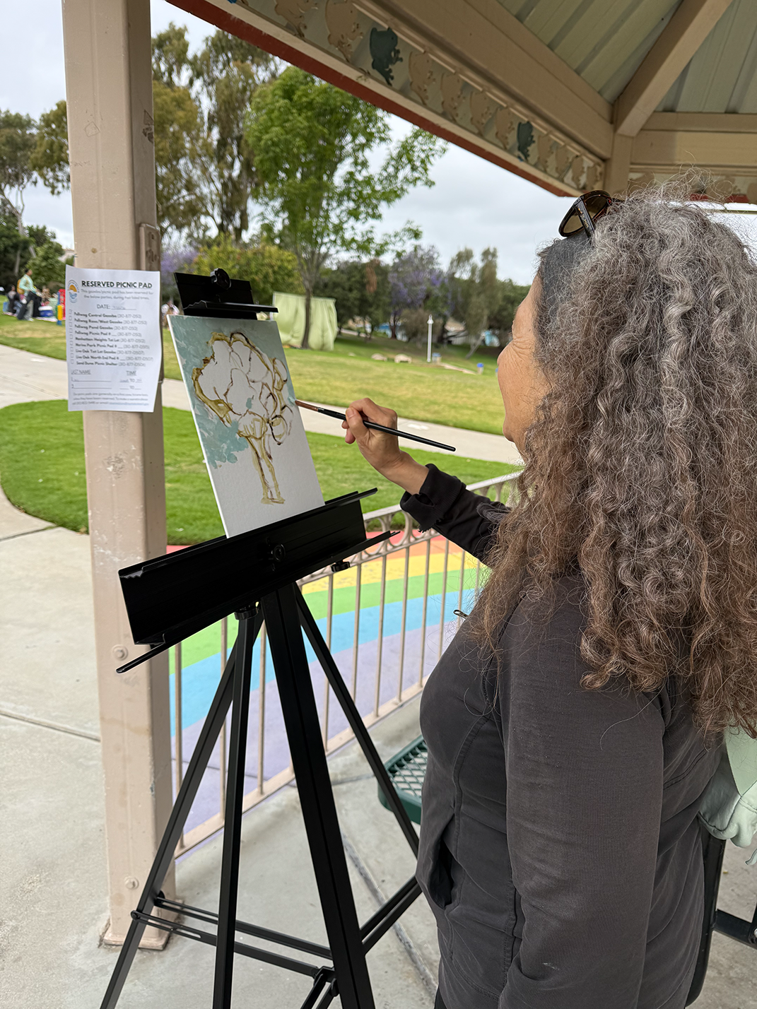 Person plein air painting outdoors on a sunny day in a workshop